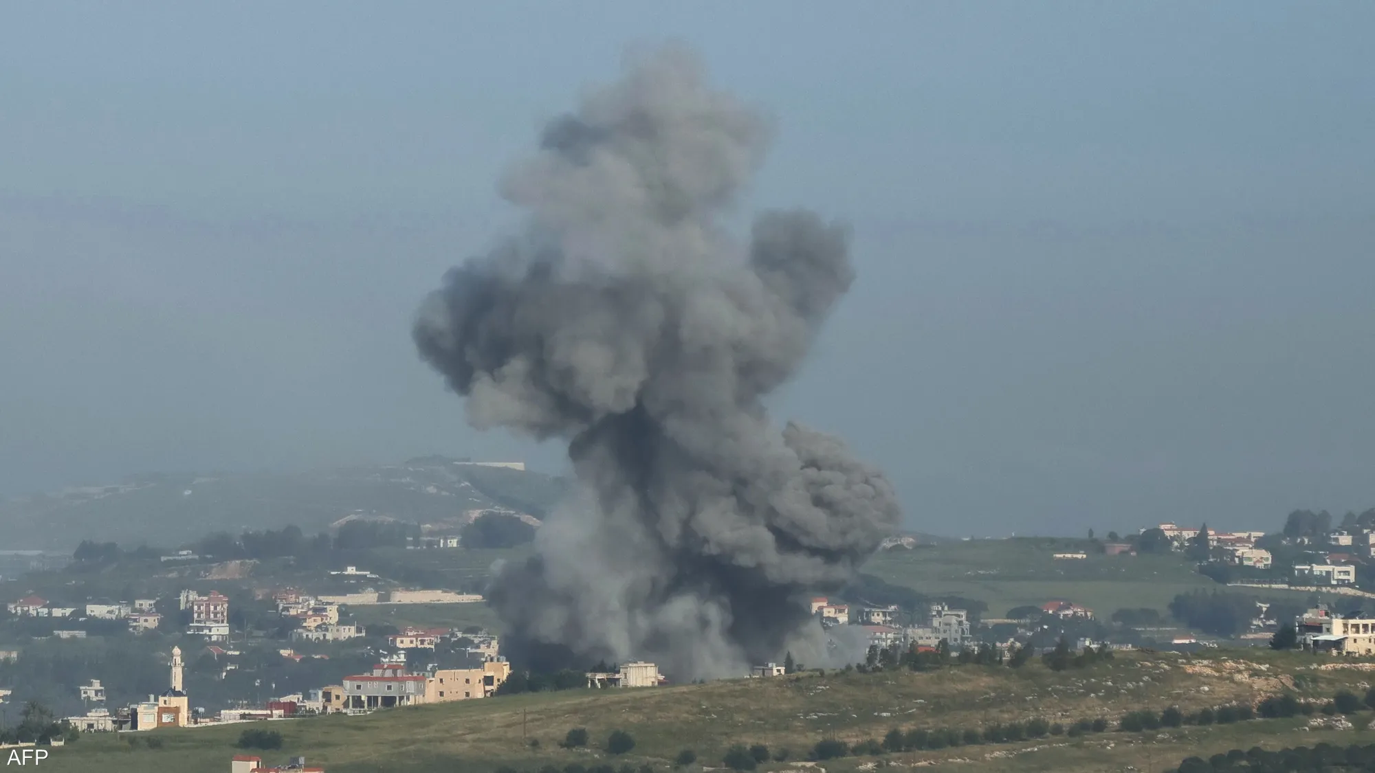 Fire and thick smoke rise from heavily destroyed buildings in Lebanon following Israeli airstrikes, shellings, and reported killings, leaving widespread destruction across the surrounding area.