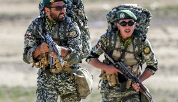 Iranian armed troops stand in formation during a military exercise, reflecting the country's ongoing emphasis on national defense and security preparedness.